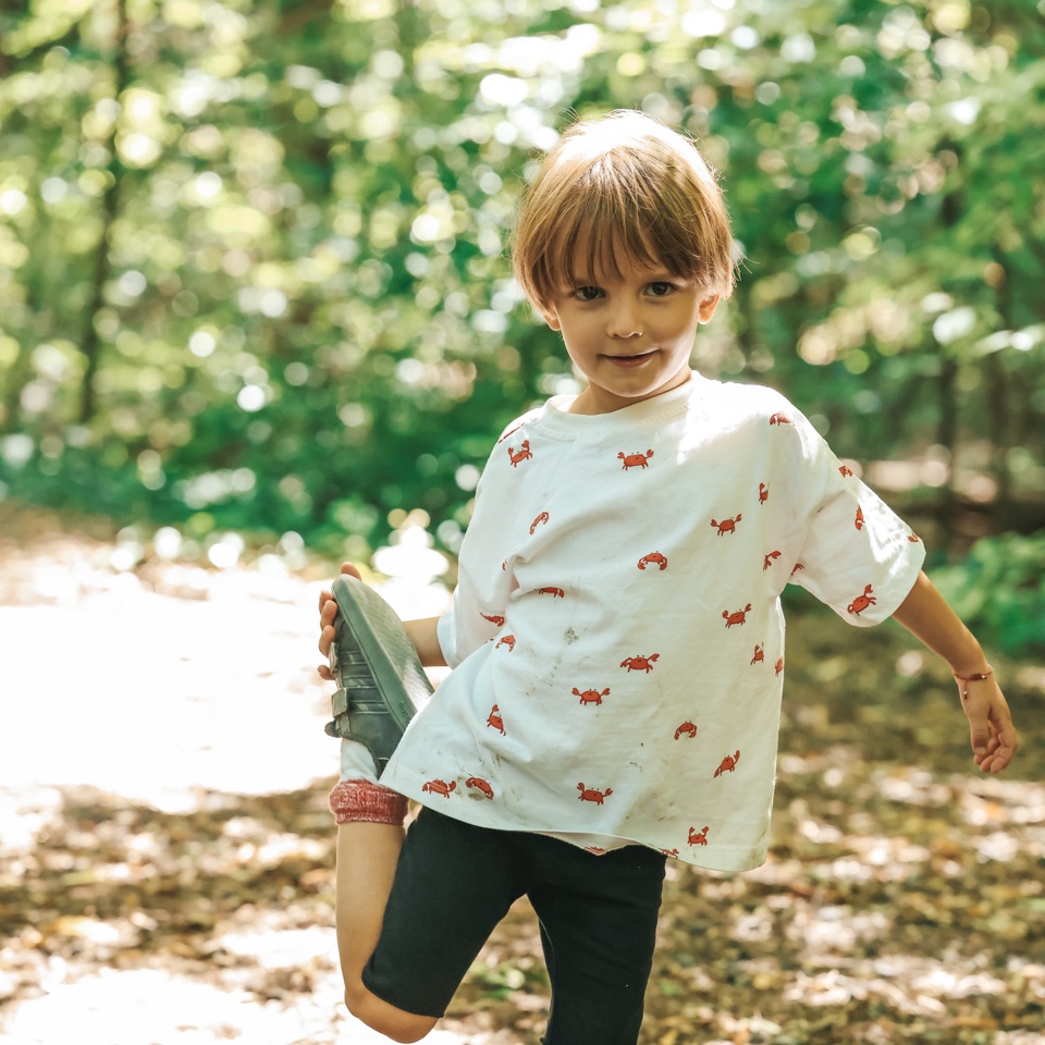 Child modelling a patterned T-shirt and shorts outdoors – photography by Filip Labanc for No Smile Needed