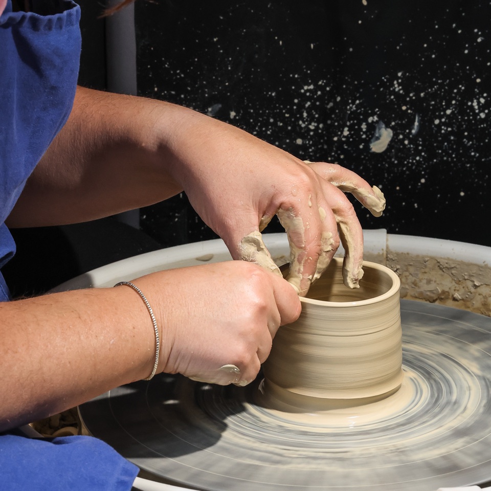 Hands shaping a ceramic vessel on a pottery wheel – photography by Filip Labanc for No Smile Needed